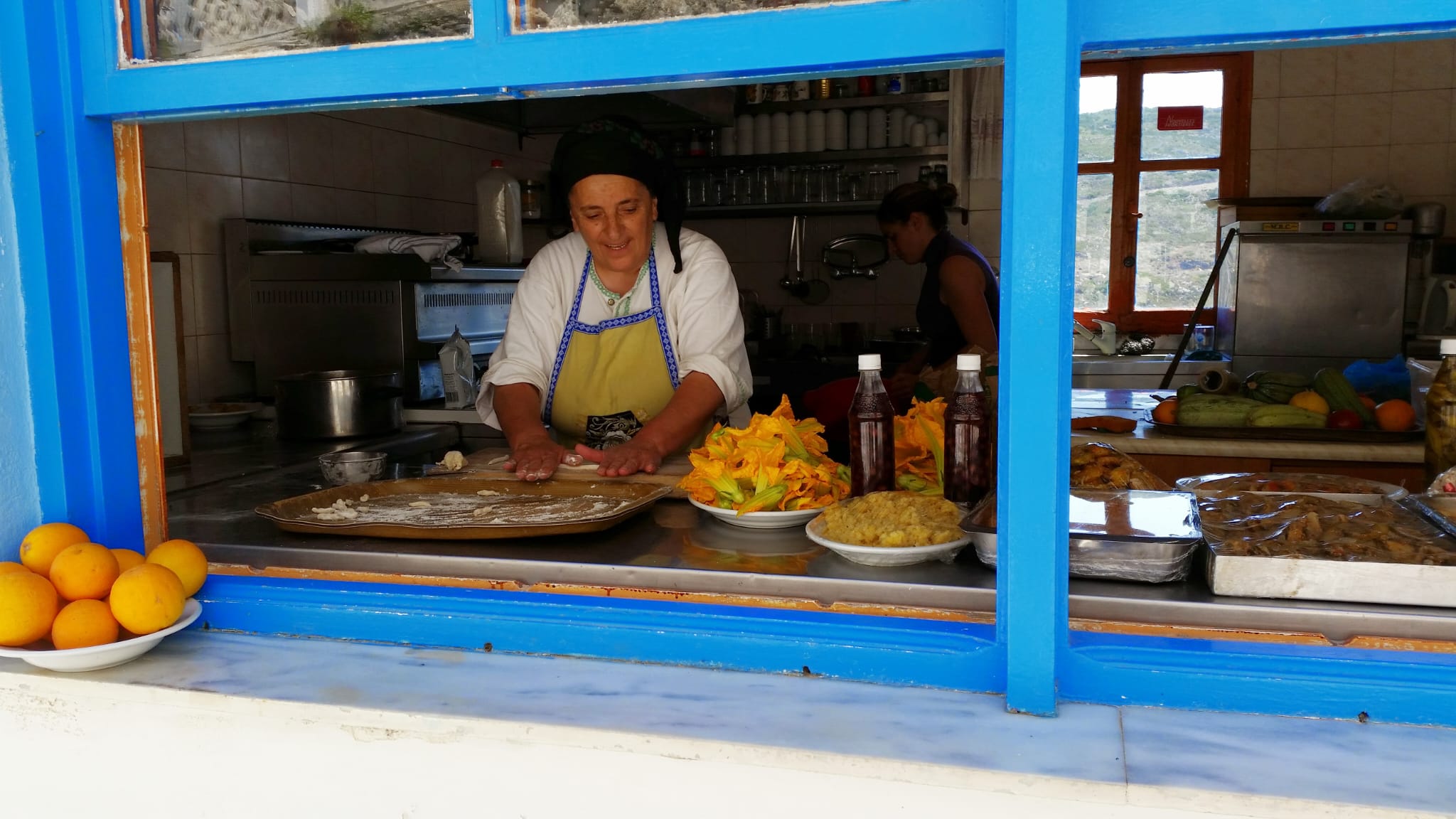 Donna prepara a mano le makarounes in una cucina di Karpathos